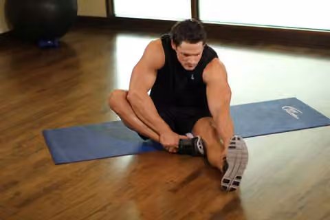 Demonstrasi gerakan Seated Floor Hamstring Stretch.