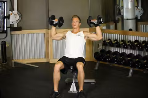Demonstrasi gerakan Seated Dumbbell Press.
