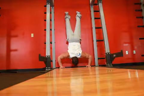 Demonstrasi gerakan Handstand Push-Ups.