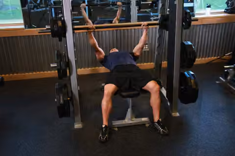 Demonstrasi gerakan Smith Machine Bench Press.