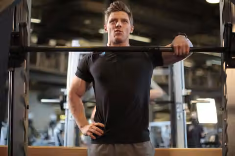 Demonstrasi gerakan Smith Machine One-Arm Upright Row.