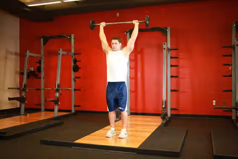 Demonstrasi gerakan Standing Barbell Press Behind Neck.