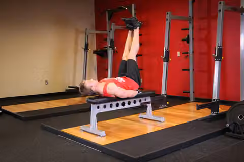 Demonstrasi gerakan Flat Bench Lying Leg Raise.